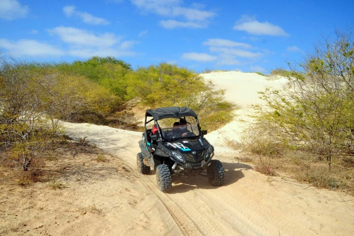 a man riding a motorcycle down a dirt road