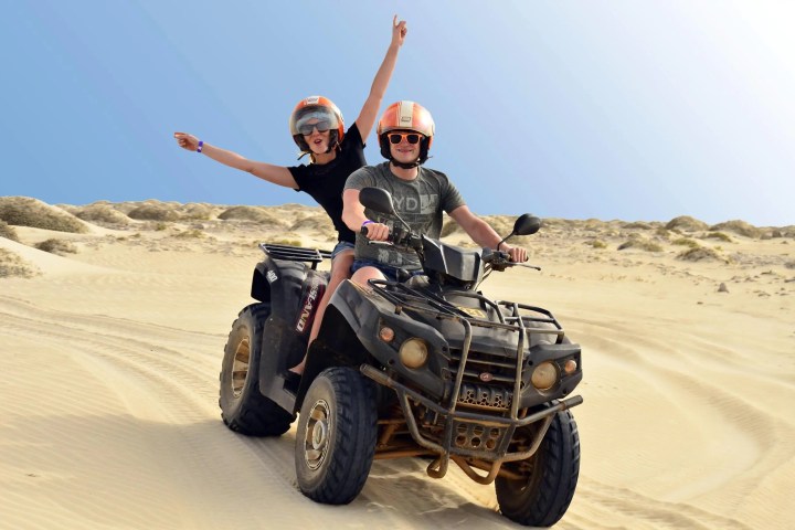 a man riding a motorcycle down a dirt road