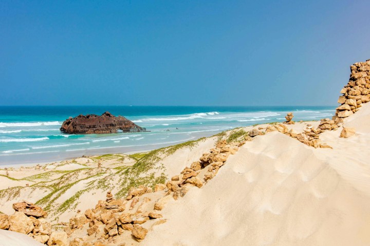 a sandy beach next to the ocean