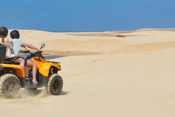 a man riding a motorcycle on a beach