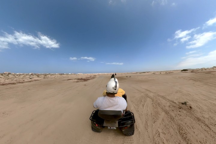 a person riding a motorcycle on a beach