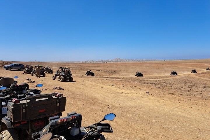 a group of people standing on top of a sandy beach