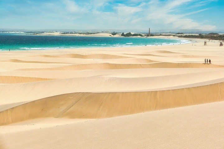 a sandy beach next to the ocean