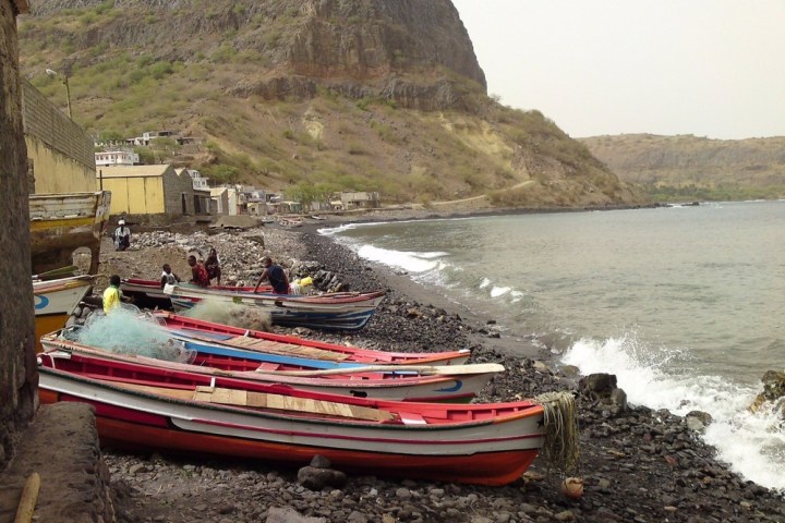 a boat sitting on top of a sandy beach