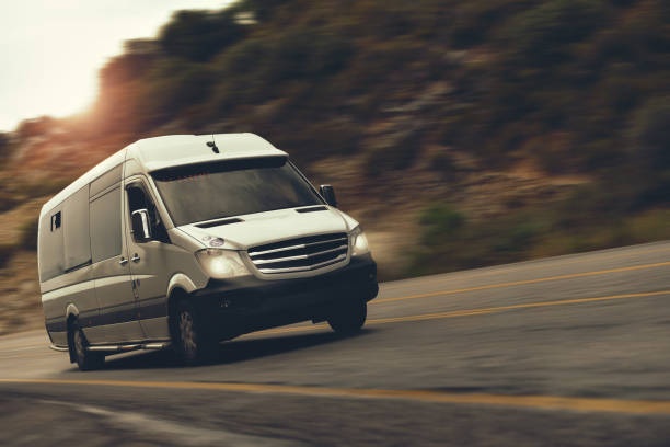White van driving on a curved road with blurred motion effect.